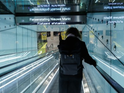 a person with a backpack is going down an escalator